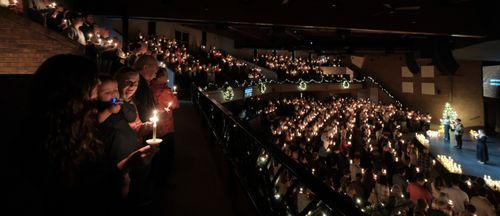 A group of people standing next to each other holding candles
