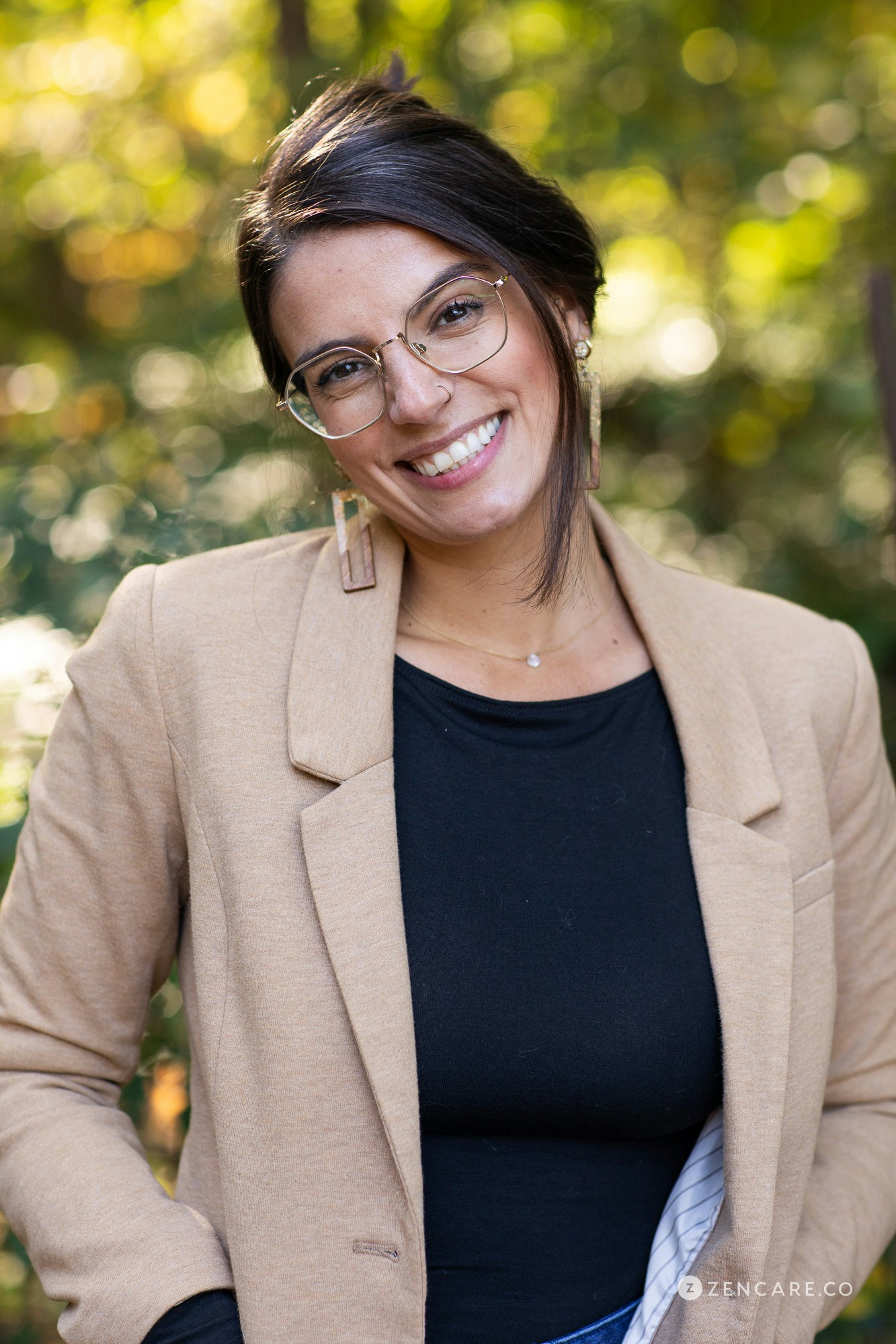 Gabriella Ruocco practicing yoga indoors with her hands up and surrounded by various green plants.