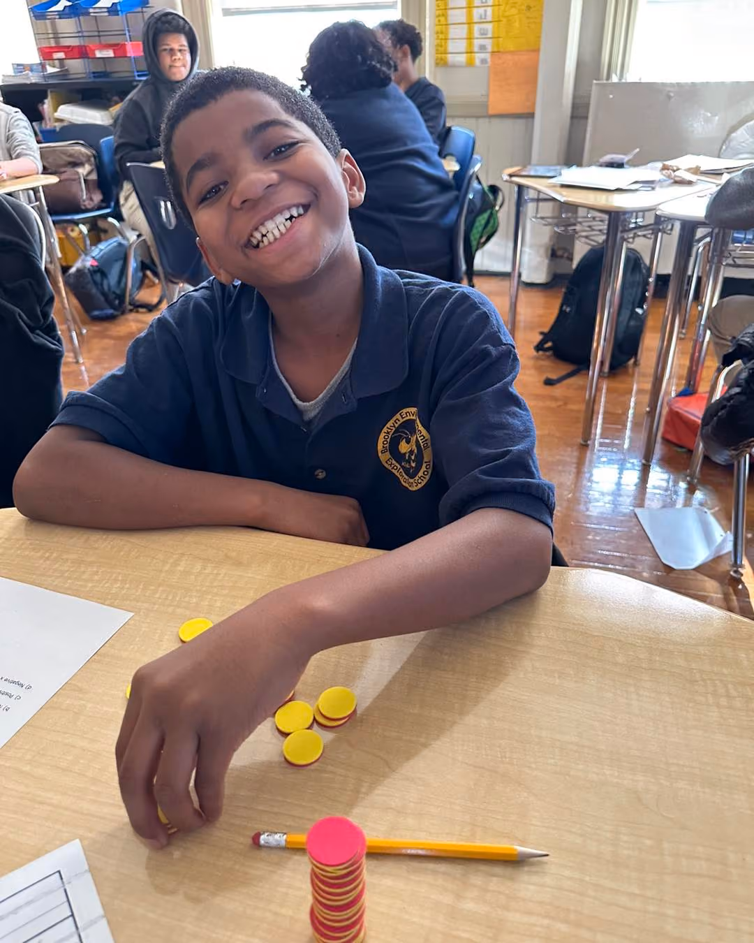 Smiling student using counting tokens during math class