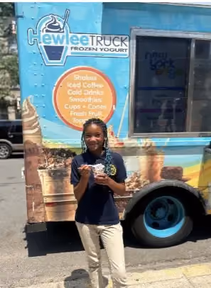 Student holding frozen yogurt treat outside Chewlee food truck