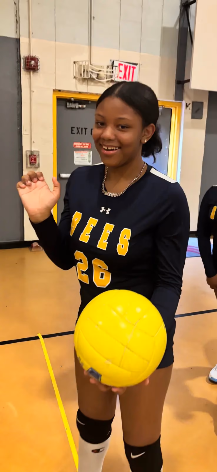 Bees volleyball player number 26 holding yellow ball in gym