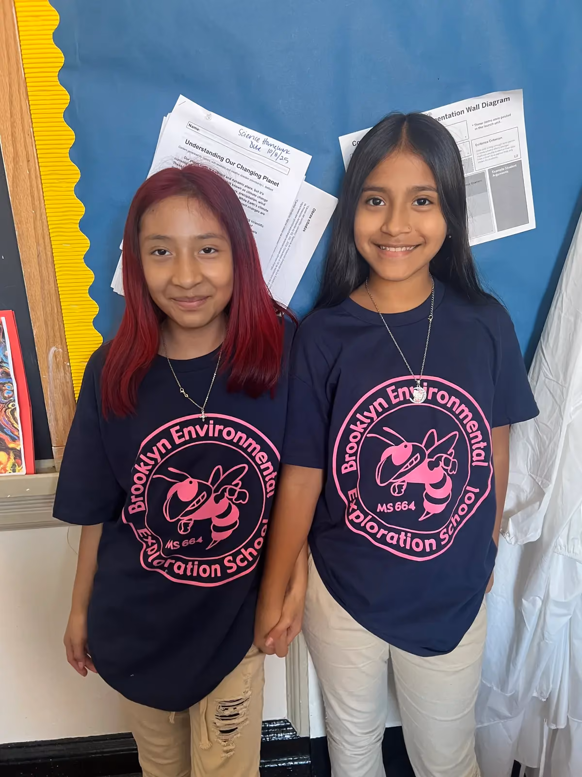 Two students smiling in Brooklyn Environmental Exploration School MS 664 shirts