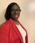 Dorla Arnold smiling in a red blazer and glasses