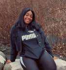 Ms. Amari Cockett smiling outdoors in casual attire