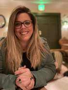 Ms. Lauren Barth smiling at the camera with glasses
