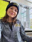 Mrs. Adonia Nanas smiling in classroom wearing Bees beanie