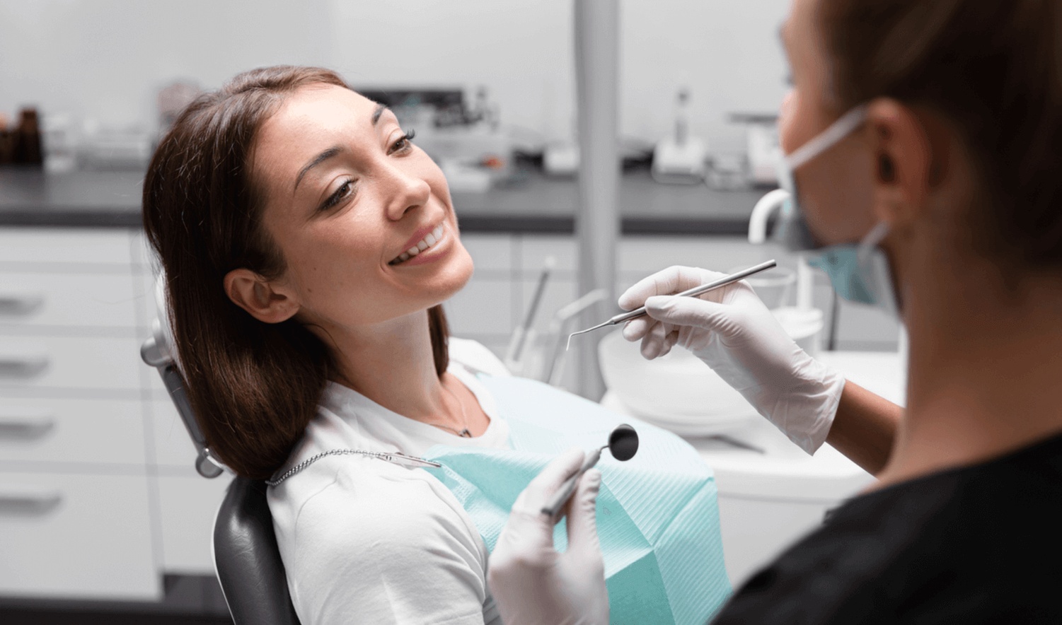 A woman at her 6-month dental check-up talks to her family dentist in Redwood City about plaque and tartar buildup