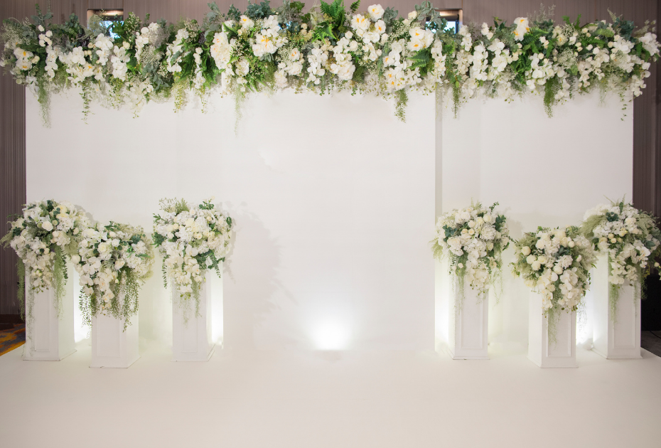 Wedding photo booth ideas of an elegant white background with white and green florals.