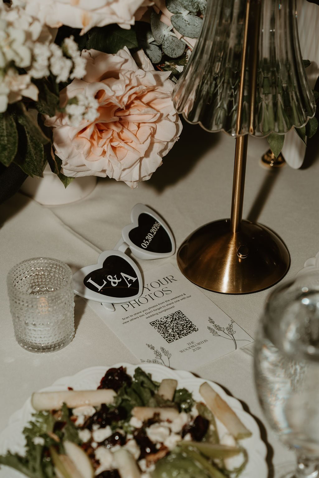 A wedding QR code on a table at the reception for collecting candid wedding photos from guests.