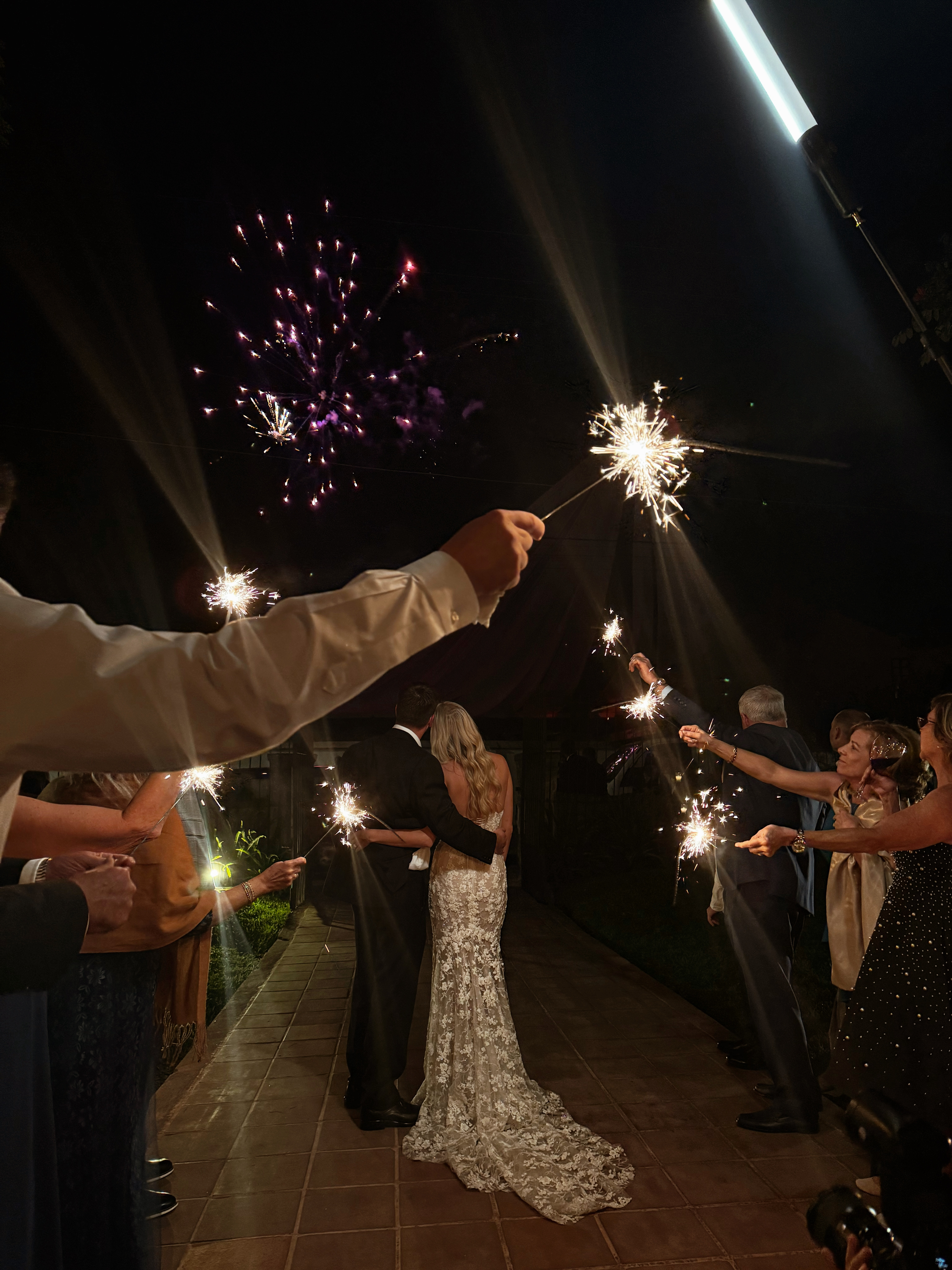 Bride and groom from behind during a sparkler exit captured by a wedding guest.