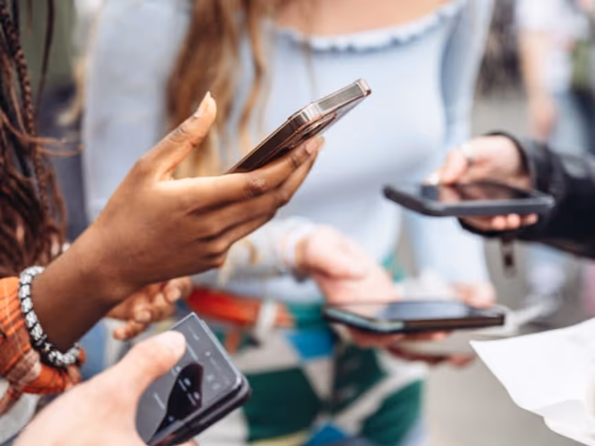 cropped images of 3 young women holding their phones, focus on the hands and phones