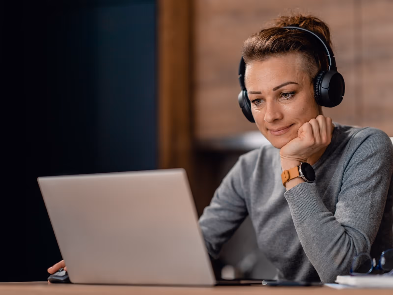 women working on laptop with headphones on. working from home. professional.