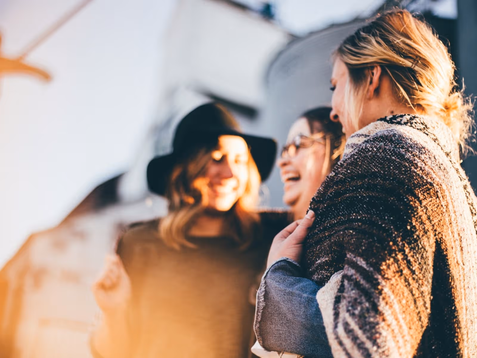 3 women out of focus laughing. sun setting. 