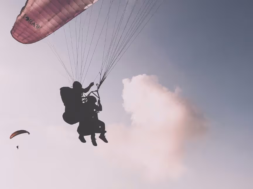 two people on a single parachute soaring through the skies