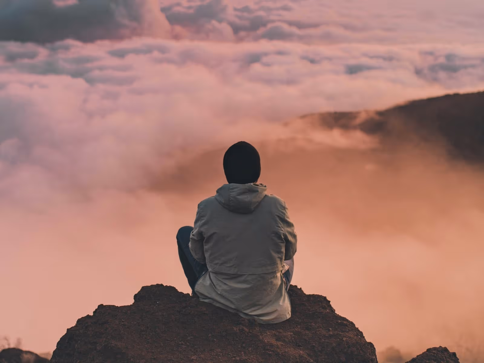 A young guy sitting on a mountain