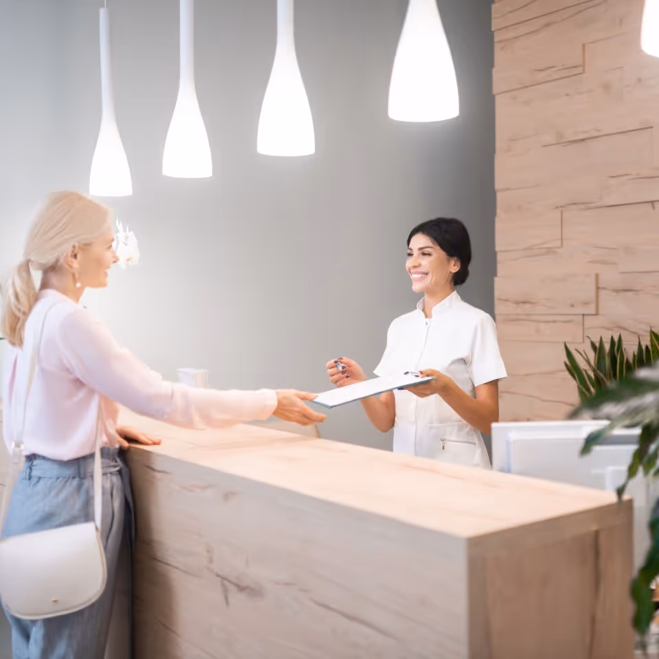 reception area of an aesthetics clinic. Nurse welcoming a women patient