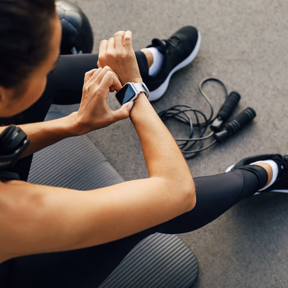 women sitting down after excersising watching her smartwatch