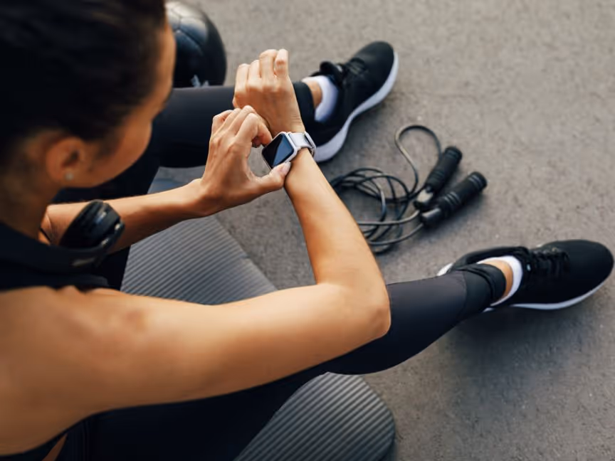 women sitting down after excersising watching her smartwatch