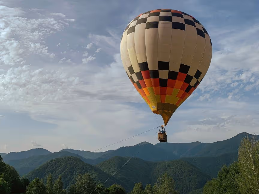 Hot air balloon floating above mountains