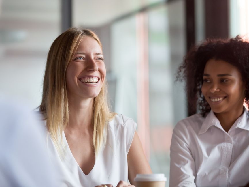 Two women at work chatting and smiling