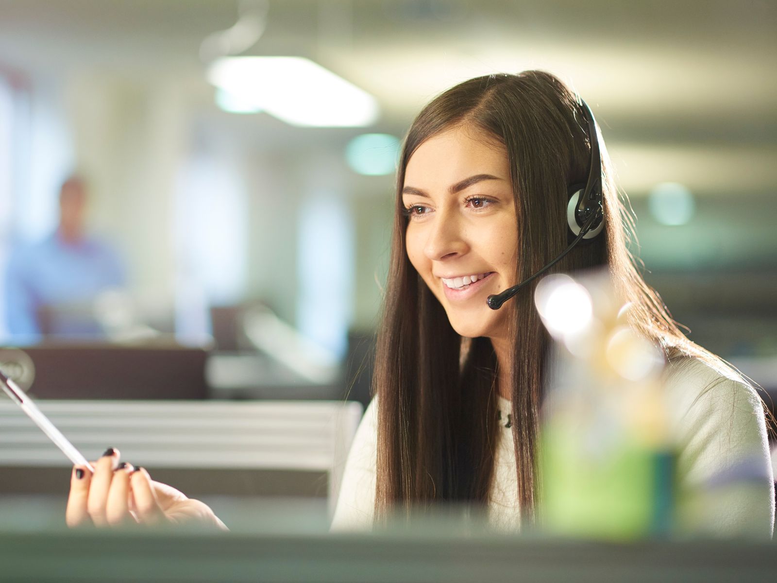 Female customer support operation manager taking a call from client.