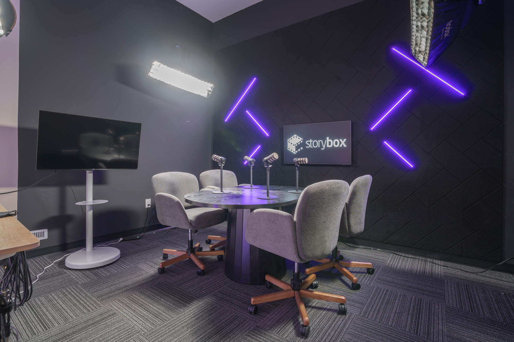 The light theme podcast set with two boucle armchairs, a microphone arm and a wood slat wall