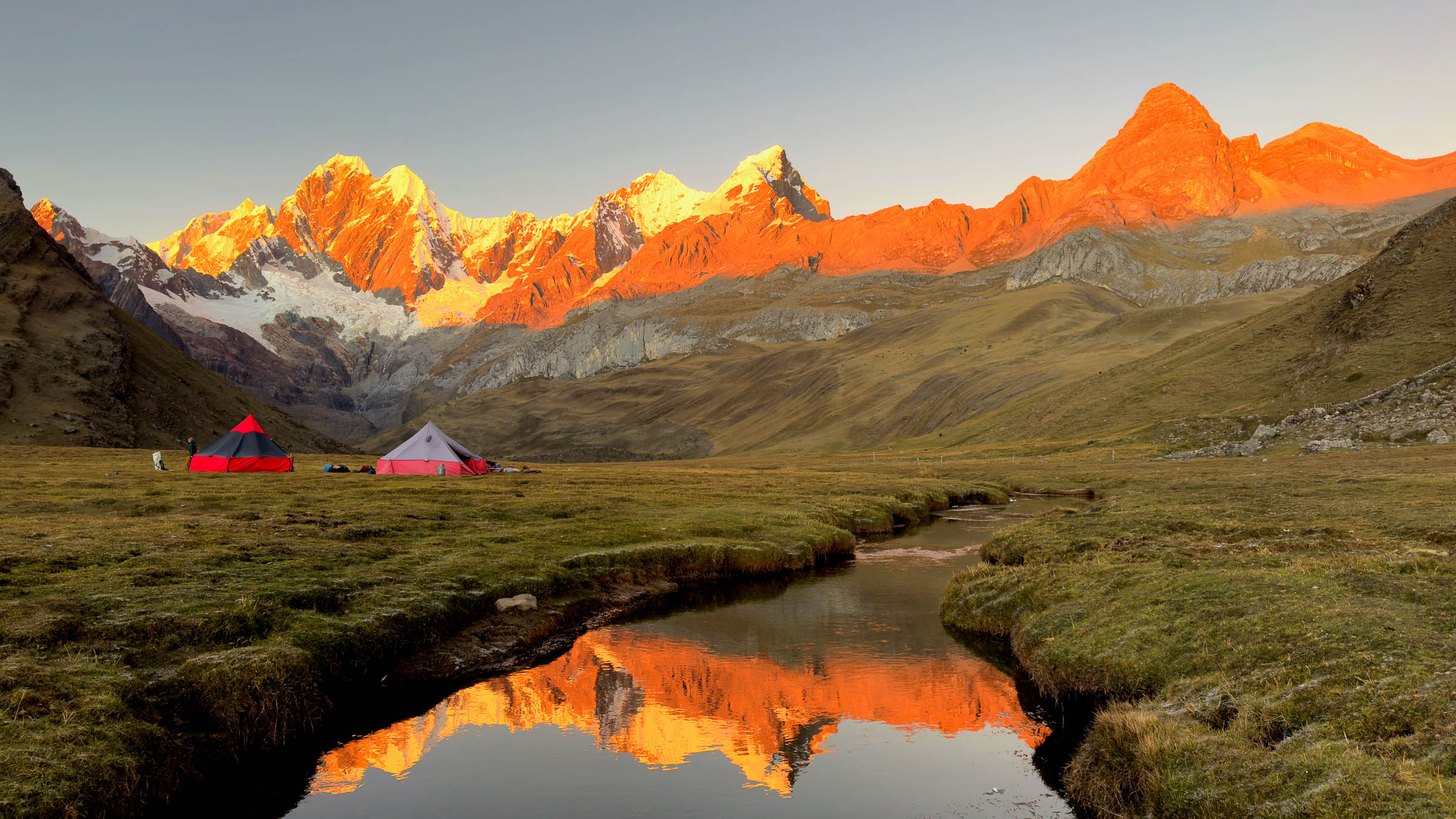 Sommets de la cordillère Huayhuash embrasés par le soleil au-dessus d’un campement