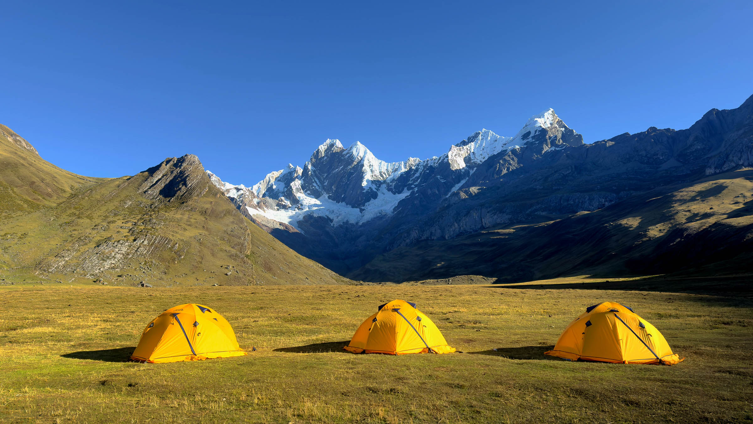 Campement de trek au pied des sommets enneigés de la cordillère Huayhuash, au Pérou