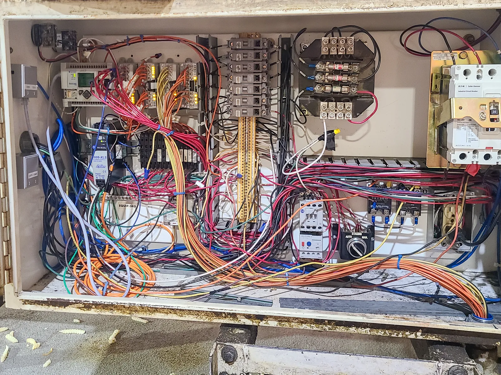 Control panel enclosure before rebuild, with unbundled wiring running loose across the backplane.