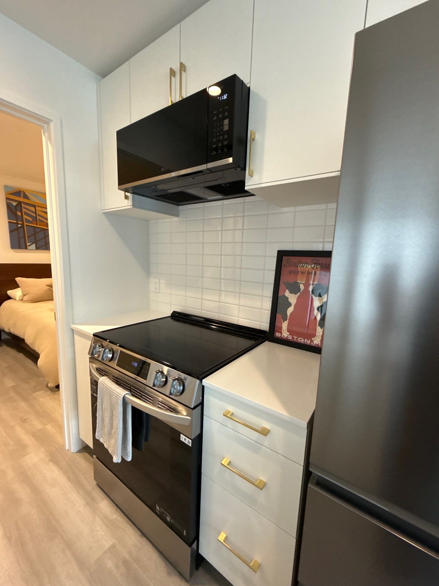 Kitchen range, white tile backsplash and stainless fridge in a Mews 532 ADU