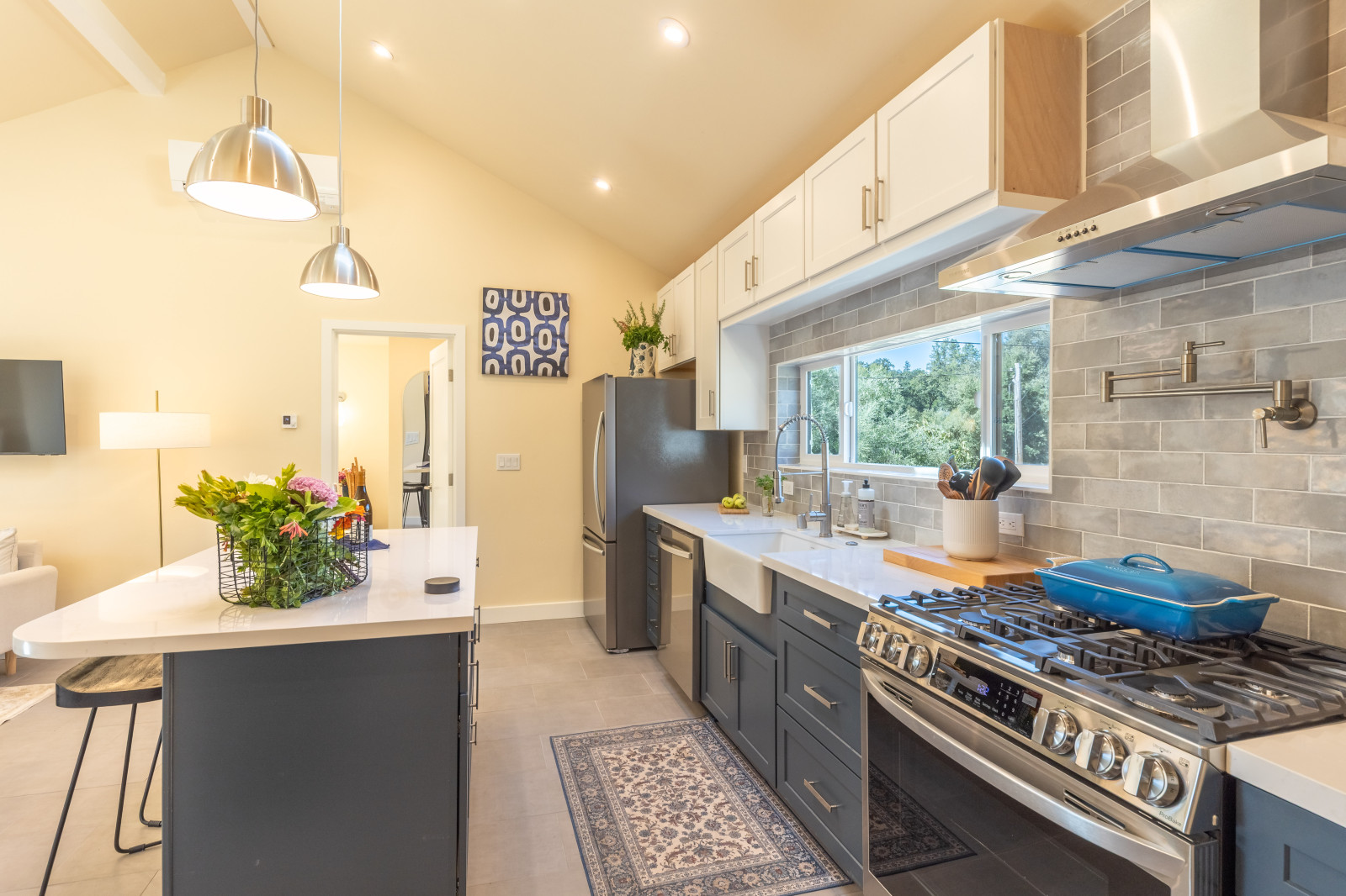 Kitchen with gas range, stainless hood and gray tile in a Barnhouse 900 ADU