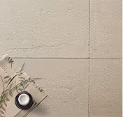 Beige textured floor tiles with thin dividing lines and a small plant along with a black round candle near a notebook on the bottom left corner.