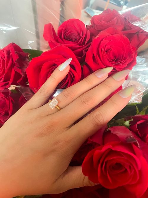 Testimonial image for Aion Diamonds & Co., showcasing an engagement ring with red roses in the background.