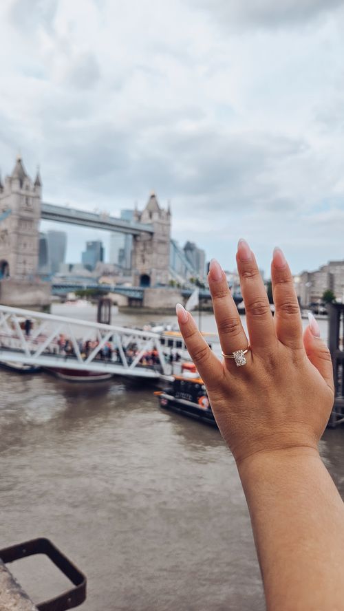 hand and engagement ring with bridge in background