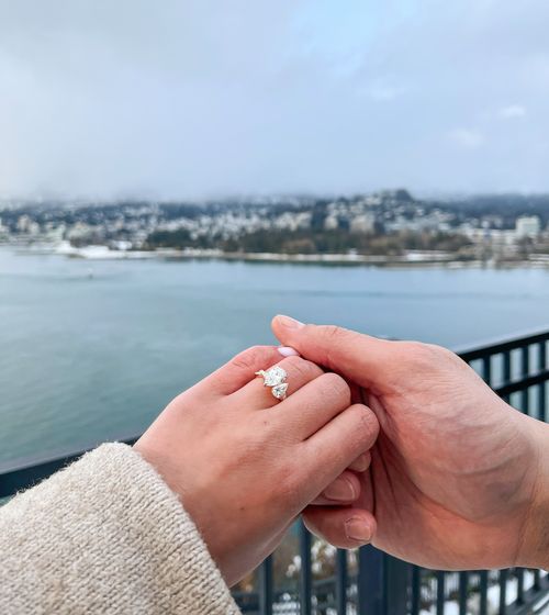 couple holding hands with engagement ring