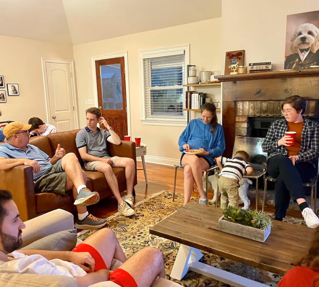 A group of people meeting and talking around the living room of a home