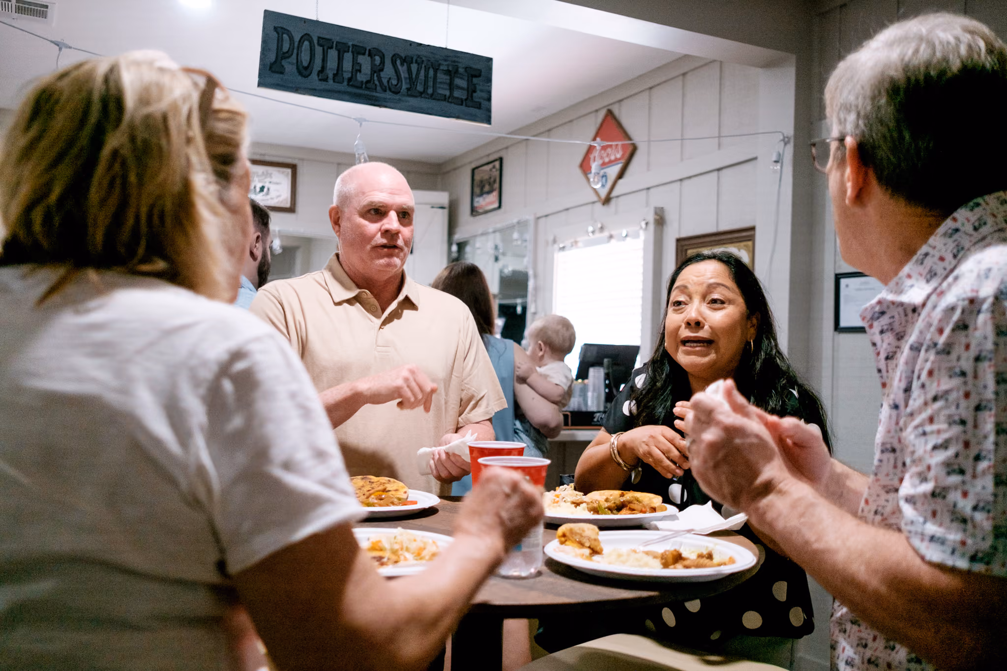 The Restoration church family sharing conversation over a meal