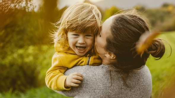 enfant embassé par sa maman, en extérieur
