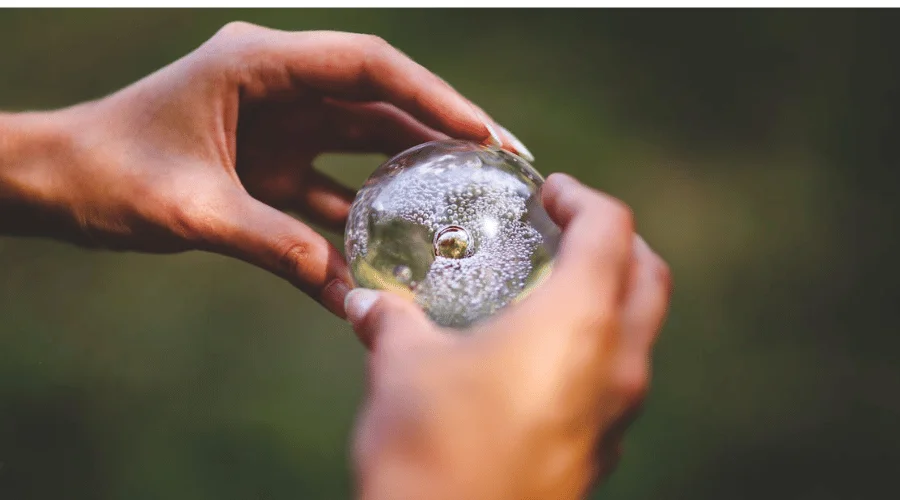 mains tenant une boule de verre