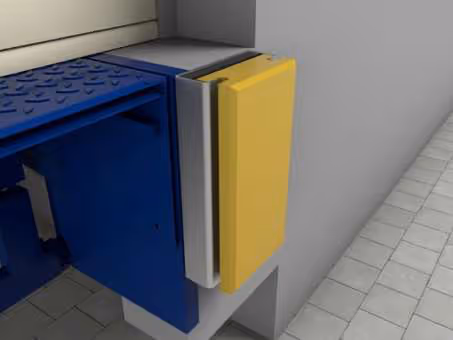 Gelbe und blaue Absperrvorrichtung an einer grauen Wand über einem gepflasterten Boden.