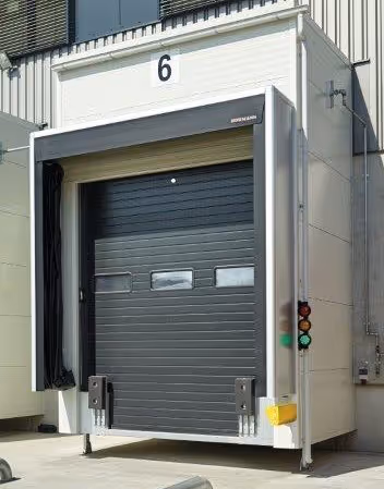 Industrielle graue Toranlage mit der Nummer 6 und integrierter Signalleuchte mit grüner und roter Lampe.