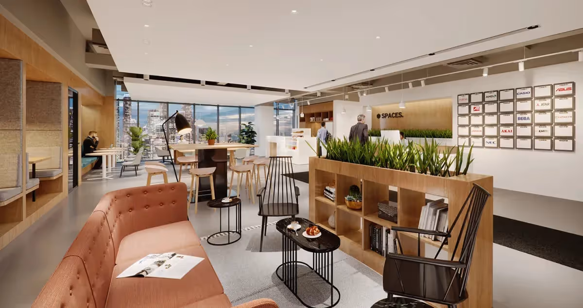 Großer Raum mit Sofas, Pflanzen, Stehtischen, Regalen, Wandleuchten, und Glasfassade mit Stadtblick im Coworking-Space.