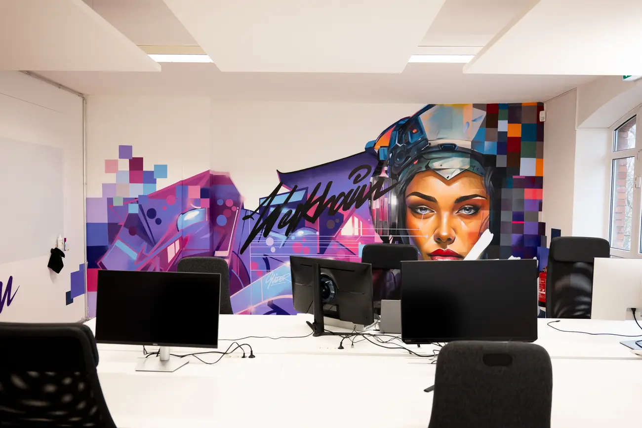 Coworking-Fläche mit Wandgemälde und höhenverstellbaren Schreibtischen im werkhain Berlin-Friedrichshain