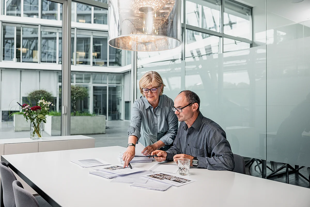 Meeting at a conference table overlooking the courtyard at ecos work spaces in the Berliner Bogen