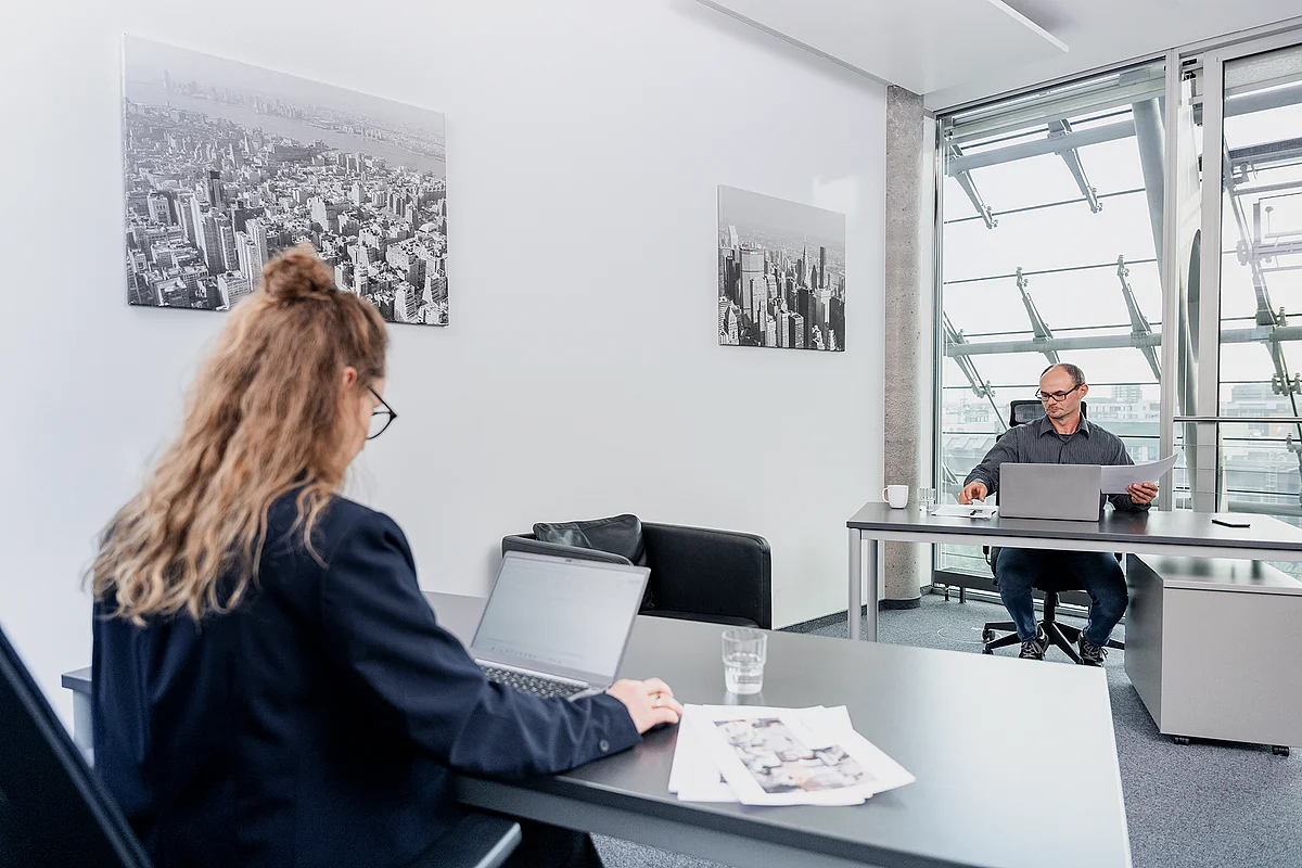 Desks in front of the steel-and-glass facade of the Berliner Bogen at ecos work spaces, Hamburg