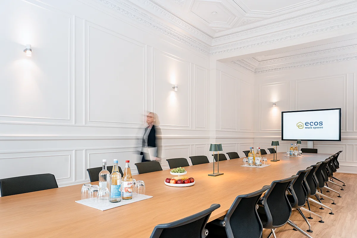 Conference room with a long table, stucco ceiling and presentation screen at ecos work spaces on the Colonnaden, Hamburg