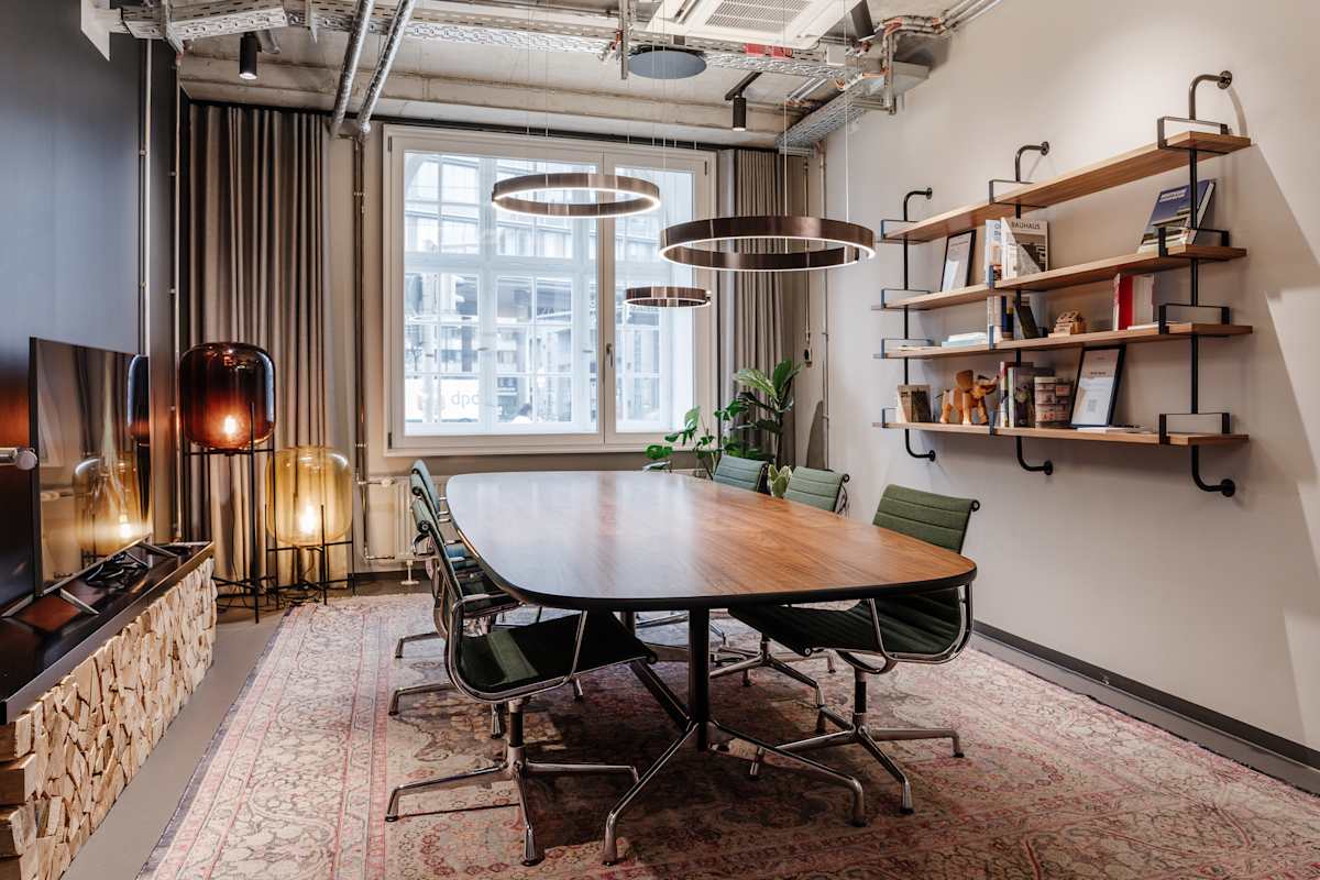 Konferenzraum mit ovalem Holztisch und Teppich, Design Offices Nürnberg Hauptbahnhof