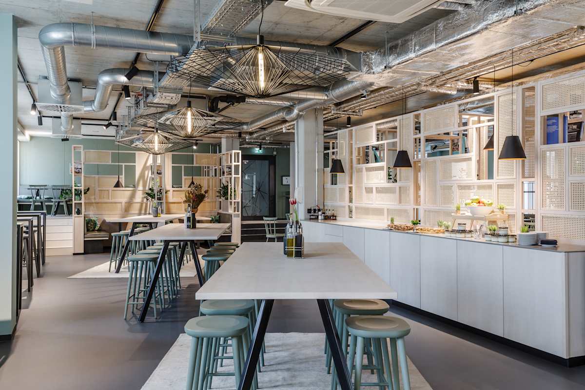 Cafébereich mit Küchenzeile und Stehtischen, Design Offices Nürnberg Hauptbahnhof