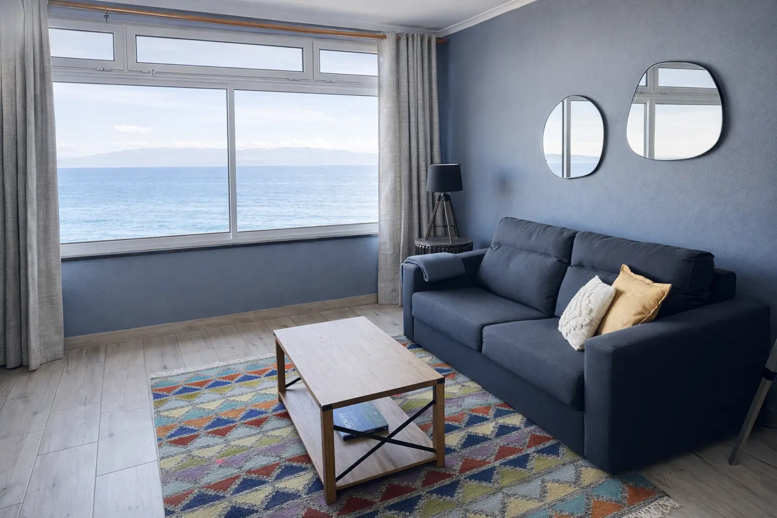 Living room at Pico Island Villas 9 with a large window overlooking the Atlantic Ocean.