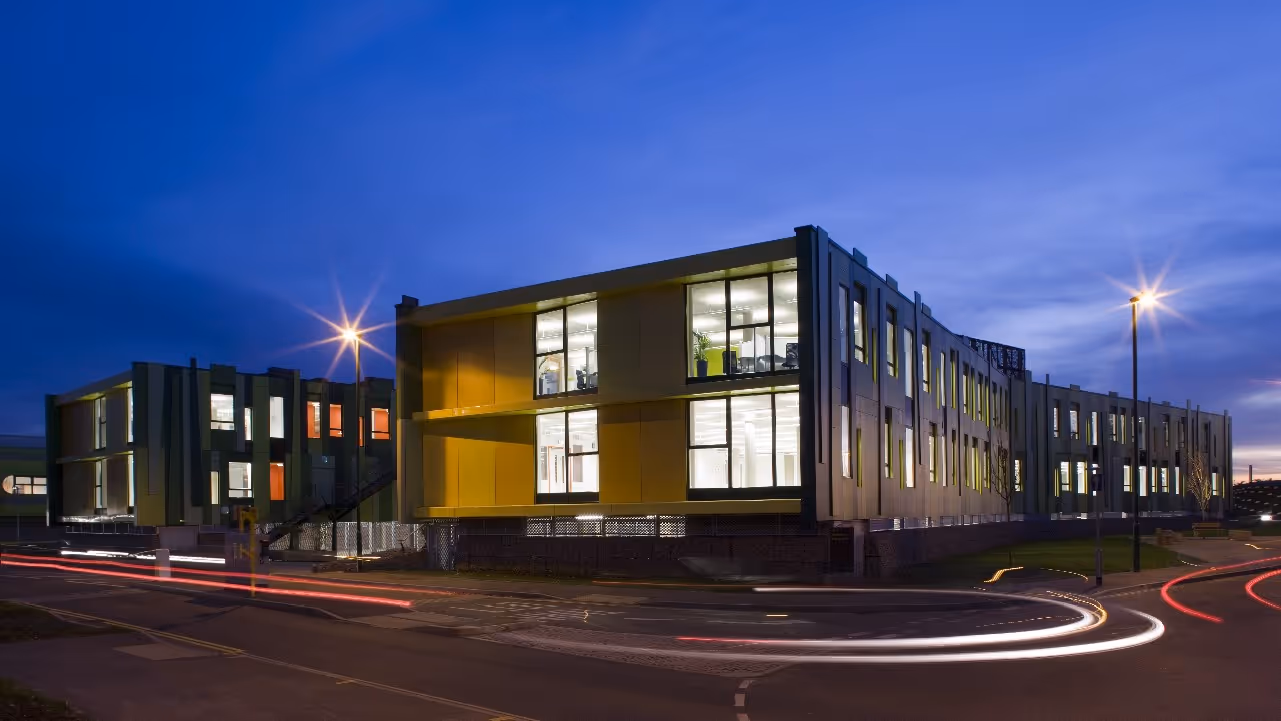 A building lit internally, against a twighlight background